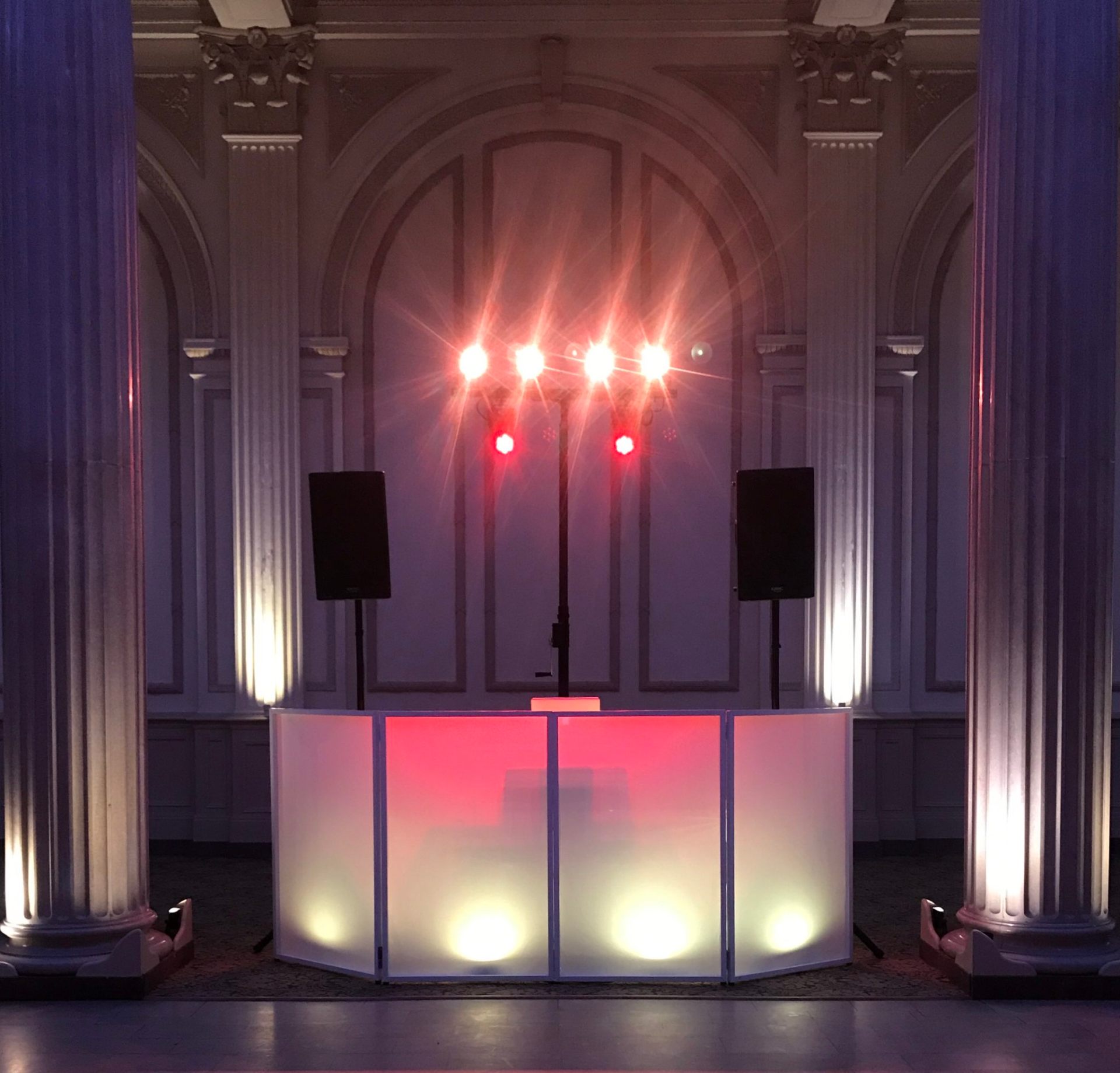 Grand ballroom DJ setup with red stage lighting